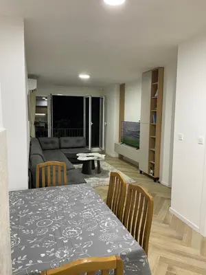 a living room with a table and a couch at Pine forest apartment in Ulcinj