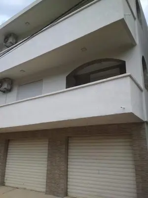 a building with two garage doors and a window at Kod Senada in Utjeha