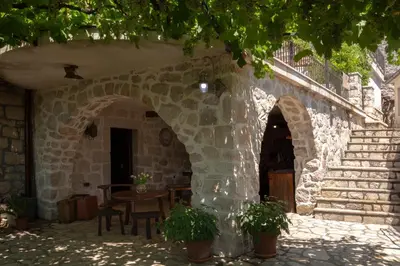 a stone building with a table and chairs and stairs at Stone Villa Oblun in Briđe