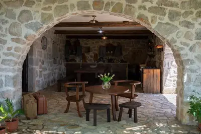 a room with a table and chairs in a stone wall at Stone Villa Oblun in Briđe