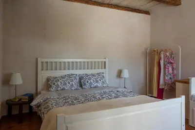 a bedroom with a white bed and two lamps at Stone Villa Oblun in Briđe