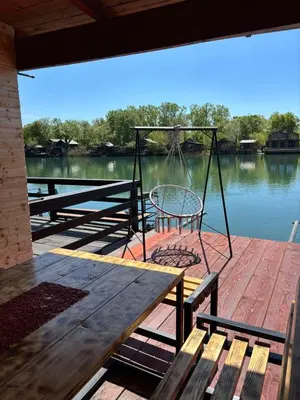 a porch with a swing and a table and bench at Kućica Vukčević Ada Bojana in Ulcinj