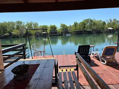a dock with chairs and a swing on the water at Kućica Vukčević Ada Bojana in Ulcinj