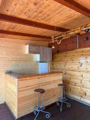 a bar in a wooden room with two stools at Kućica Vukčević Ada Bojana in Ulcinj