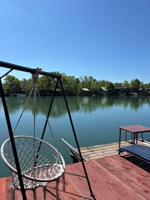 a chair sitting on a dock next to the water at Kućica Vukčević Ada Bojana in Ulcinj