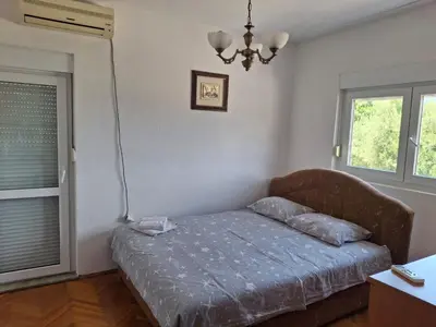 a bedroom with a bed and two windows at Vila Šeki in Bar