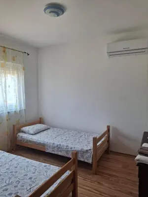 a bedroom with two beds and a air conditioner at Vila Šeki in Bar