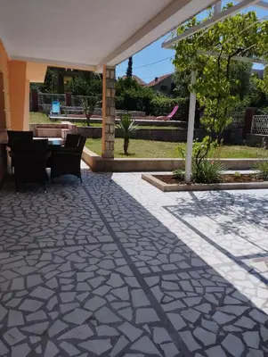 a patio with a table and chairs in a yard at Vila Šeki in Bar