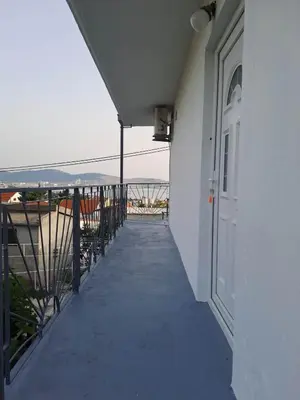 a walkway leading to a white building with a door at apartman ANAMI in Bar