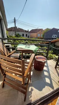 a pair of wooden chairs sitting on a patio at HeArt of Old Town Guesthouse in Podgorica