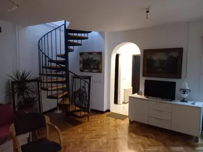 a living room with a spiral staircase and a television at HeArt of Old Town Guesthouse in Podgorica