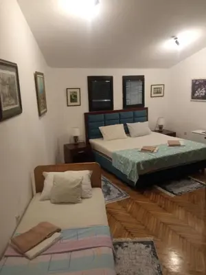 a bedroom with two beds and a couch at HeArt of Old Town Guesthouse in Podgorica