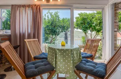 a dining room with a table and chairs and a window at Sea Oasis Apartments - Milosevic in Kotor