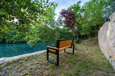 a bench sitting next to a body of water at Rijeka Zeta, Podgorica in Podgorica