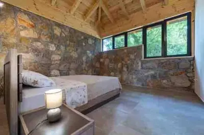 a bedroom with a bed and a table with a lamp at Rijeka Zeta, Podgorica in Podgorica