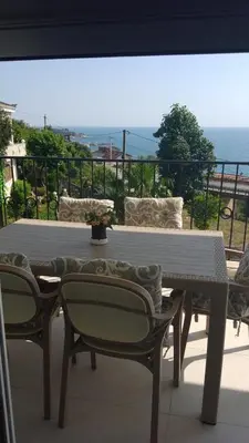 a table and chairs on a balcony with a view of the ocean at Vila HELENA in Dobra Voda