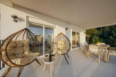 a porch with two swing chairs and a table at Vila HELENA in Dobra Voda