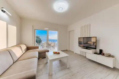 a living room with a couch and a tv and a table at Vila HELENA in Dobra Voda