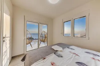a bedroom with a bed and a view of the ocean at Vila HELENA in Dobra Voda