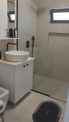 a bathroom with a sink and a glass shower at Vila HELENA in Dobra Voda