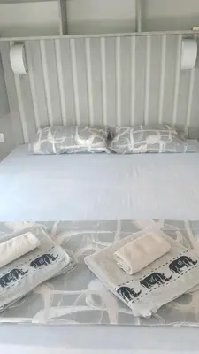 a white bed with two pillows on top of it at Vila HELENA in Dobra Voda