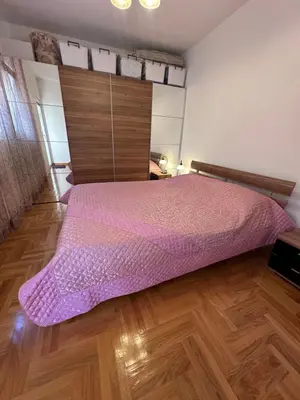 a bedroom with a bed with a pink bedspread at Apartments Comfort Petrovac in Petrovac na Moru