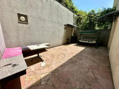 a patio with a table and a bench next to a wall at Apartments Comfort Petrovac in Petrovac na Moru