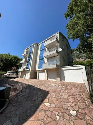 an apartment building with a parking lot in front of it at Apartments Comfort Petrovac in Petrovac na Moru