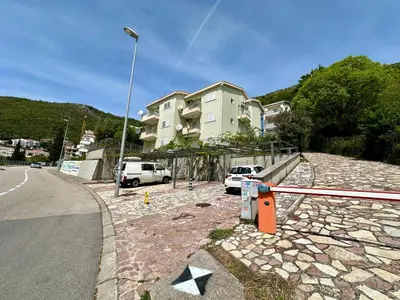 a building with cars parked on the side of a street at Apartments Comfort Petrovac in Petrovac na Moru
