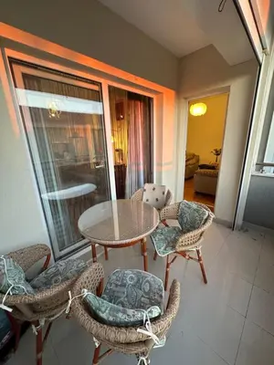 a living room with a table and chairs and a balcony at Apartments Comfort Petrovac in Petrovac na Moru