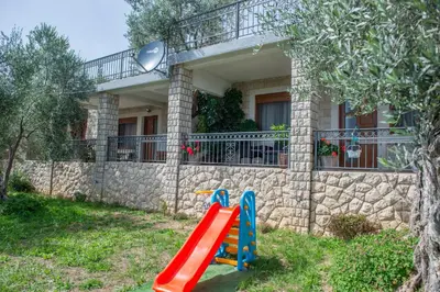 a playground in front of a house with a slide at Rustic Olive House in Ulcinj