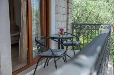 a table and two chairs on a balcony at Rustic Olive House in Ulcinj