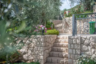 a stone retaining wall with a gate and stairs at Rustic Olive House in Ulcinj