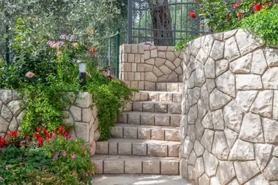 a stone staircase in a garden with flowers at Rustic Olive House in Ulcinj