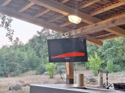 a flat screen tv on a stand under a roof at Village house Katarina in Cetinje