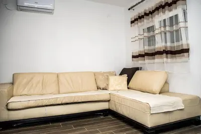 a couch sitting in a living room next to a window at Village house Katarina in Cetinje