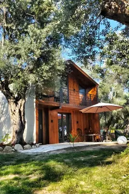 a wooden house with an umbrella in front of it at Coratina Cottage in Ulcinj