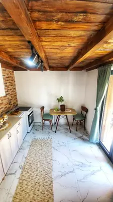 a kitchen with a table and chairs in a room at Coratina Cottage in Ulcinj