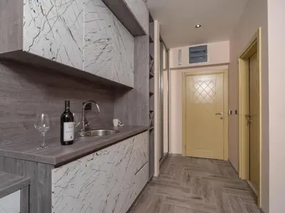 a kitchen with a sink and a bottle of wine at Hotel Diman in Dobra Voda