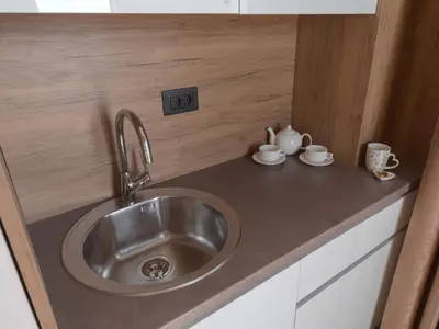 a kitchen counter with a sink and two cups at Hotel Diman in Dobra Voda