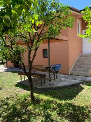 a picnic table and a bench in front of a house at Apartments Moskov in Kotor