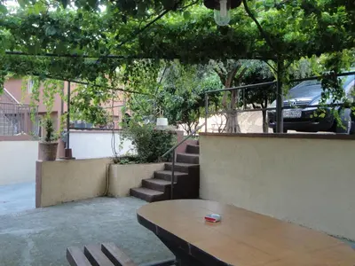 a patio with a wooden table and some stairs at Apartments Moskov in Kotor