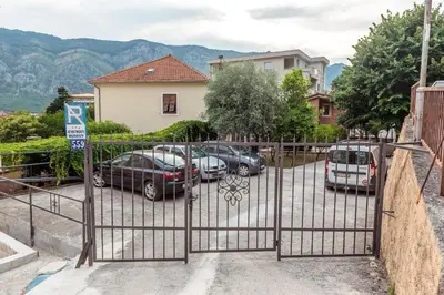 a gate with cars parked in a parking lot at Apartments Moskov in Kotor
