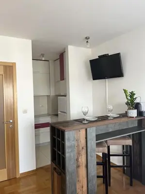a kitchen with a table with two wine glasses on it at Studio Pao in Podgorica