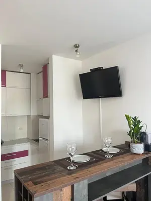a kitchen with a wooden table with two wine glasses at Studio Pao in Podgorica
