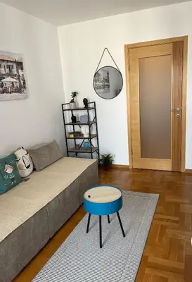 a living room with a couch and a blue stool at Studio Pao in Podgorica