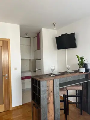 a kitchen with a table with two wine glasses on it at Studio Pao in Podgorica