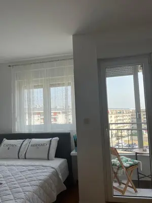 a bedroom with a bed and a mirror and a window at Studio Pao in Podgorica