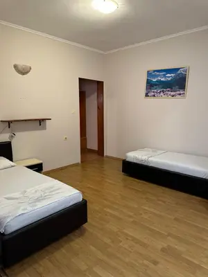 a bedroom with two beds and a wooden floor at Apartments Sella in Ulcinj