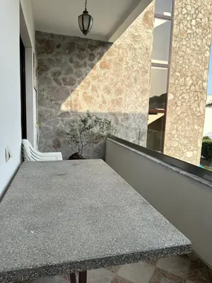a table in a room with a stone wall at Apartments Sella in Ulcinj